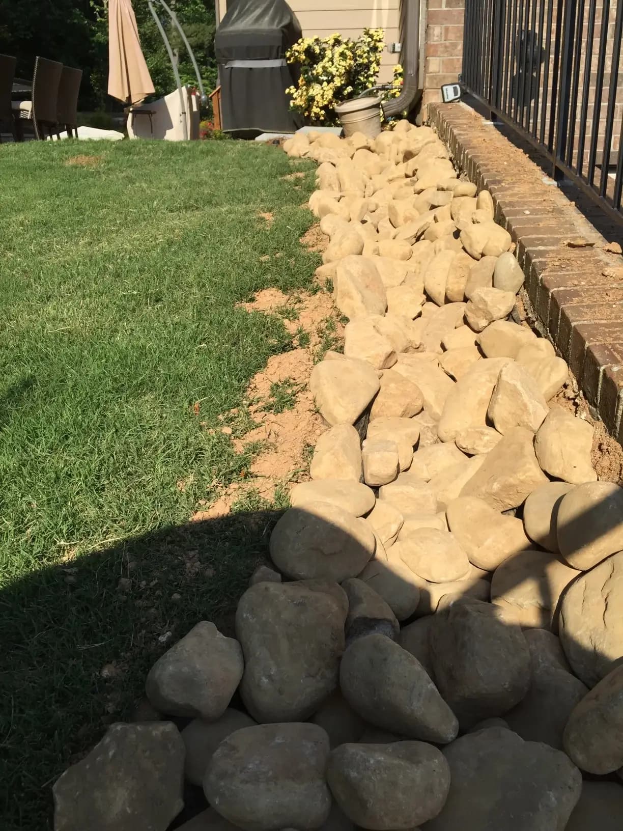 Backyard from bottom, showing off rocks for water drainage